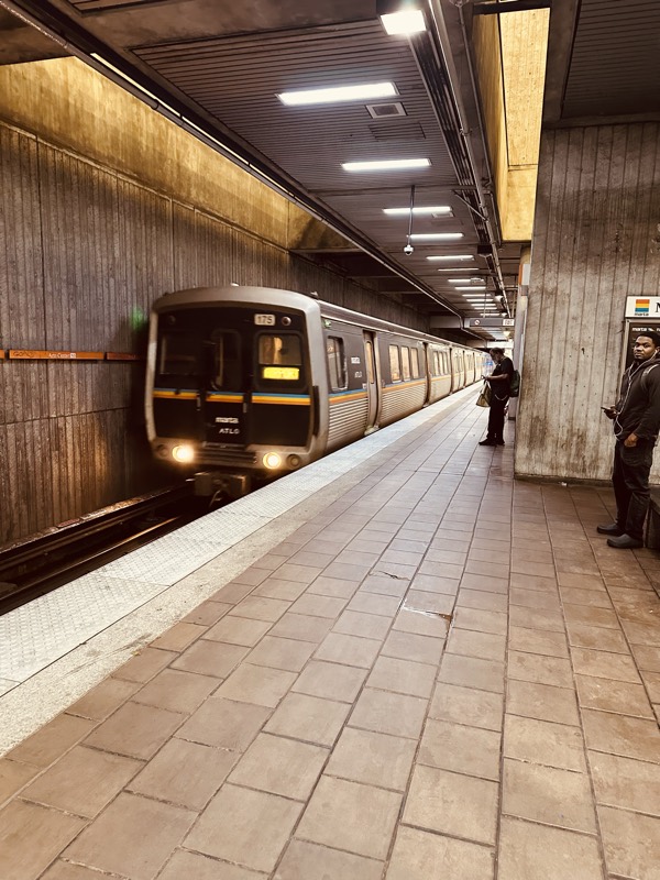 A MARTA train arrives at a platform; the platform tiles show years of accumulated grime.
