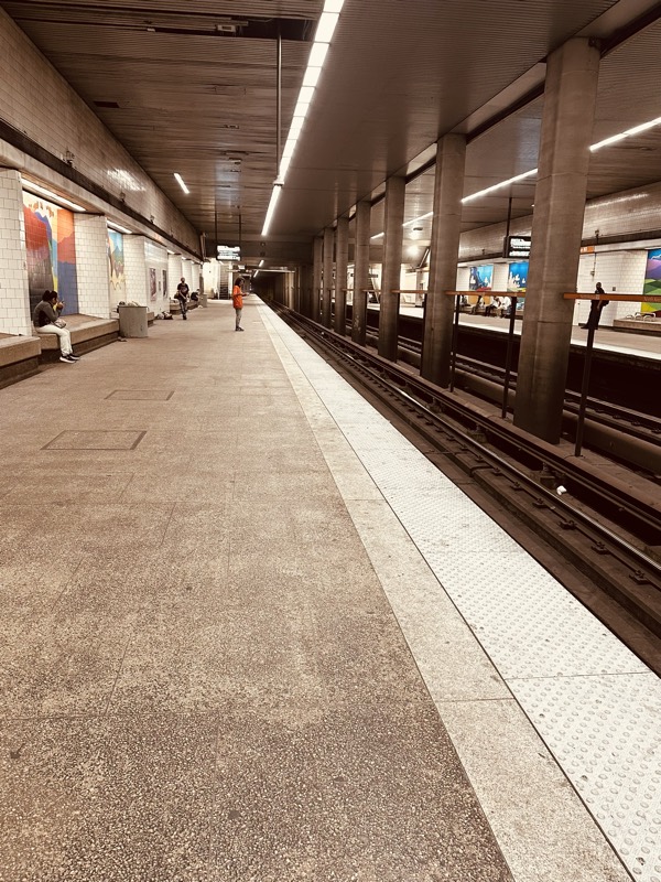 An empty MARTA platform with a mural visible at the far end, in low light.